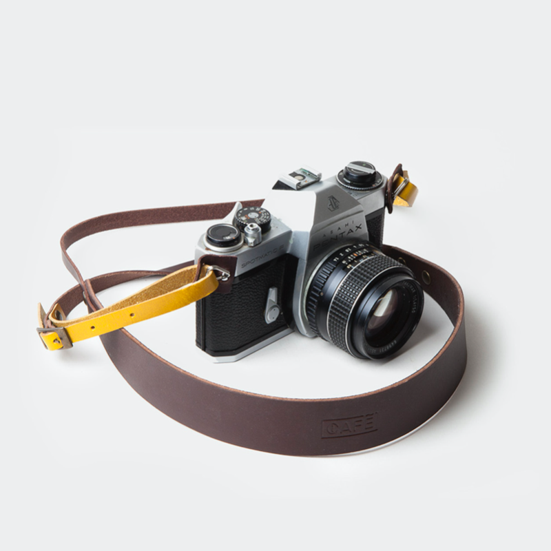 Dragonne en cuir de couleur marron et jaune pour appareil photo. Café Leather. Camera strap. Sangle cuir pour appareil photo. Accessoire pour transporter l'appareil photo. Sangle en cuir fabriqué à la main. Une bonne idée cadeau chez Robin concept store masculin, boutique en ligne de cadeau pour homme. Annecy