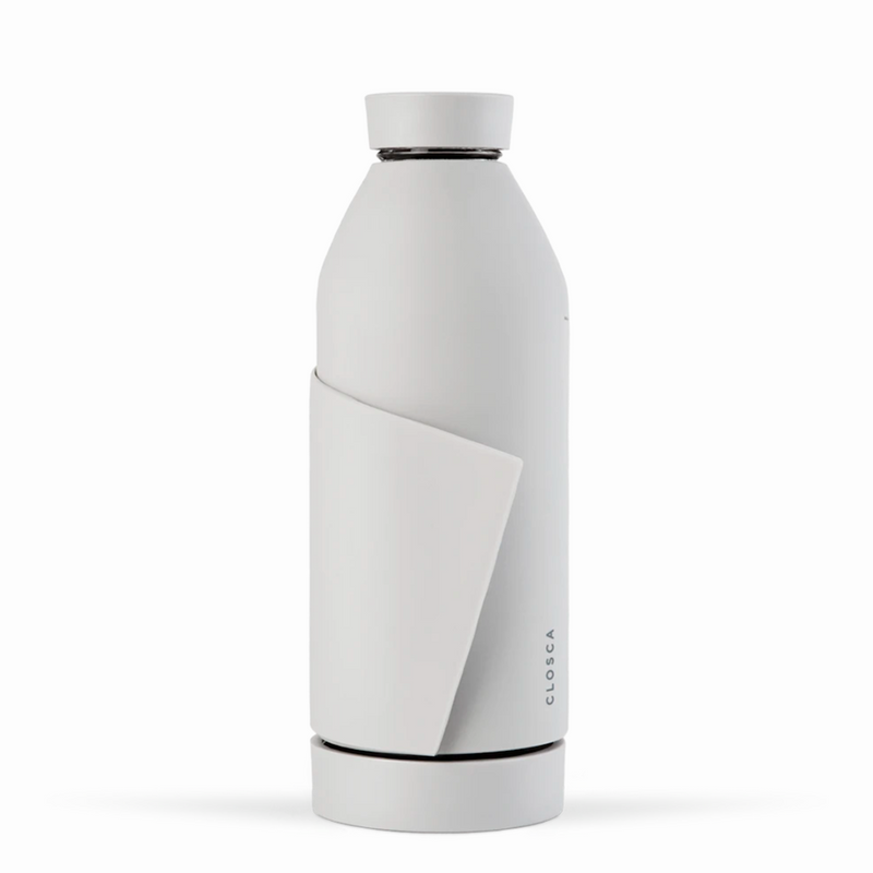 Gourde en verre avec un revêtement en silicone blanc et sa lanière . Gourde design minimaliste, pratique, deux ouverture, lanière pour fixer la gourde Closca partout, sur le vélo, le sac. Chez Robin concept store homme; boutique en ligne de cadeau pour homme. Annecy