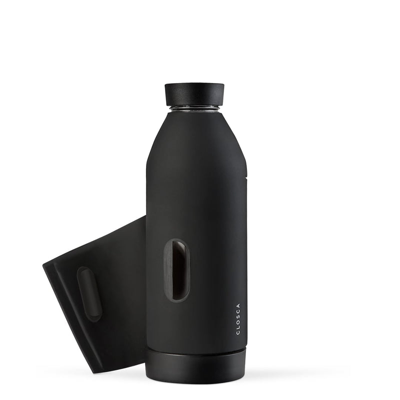 Gourde en verre avec un revêtement en silicone noir et sa lanière . Gourde design minimaliste, pratique, deux ouverture, lanière pour fixer la gourde Closca partout, sur le vélo, le sac. Bouteille en verre, accessoire de vélo, randonnée. Chez Robin concept store homme; boutique en ligne de cadeau pour homme. Annecy