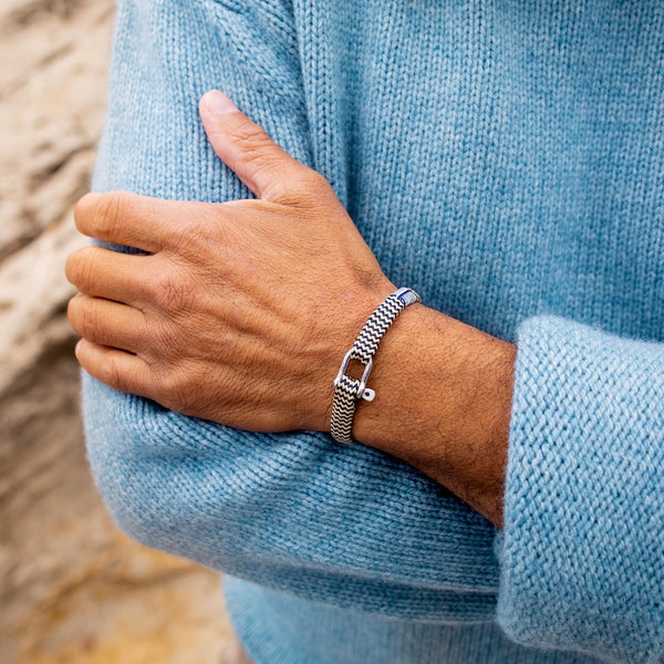 Photo lifestyle Bracelet beige et bleu tréssé avec des cordages de bateau recyclé. Bracelet Vicious Vik beige et bleu de Pig and Hen. Corde de bateau recyclé tréssé fini avec un fermoir manille. Tendance lifestyle pour homme chez Robin concept store masculin, boutique en ligne de cadeau pour homme. Annecy