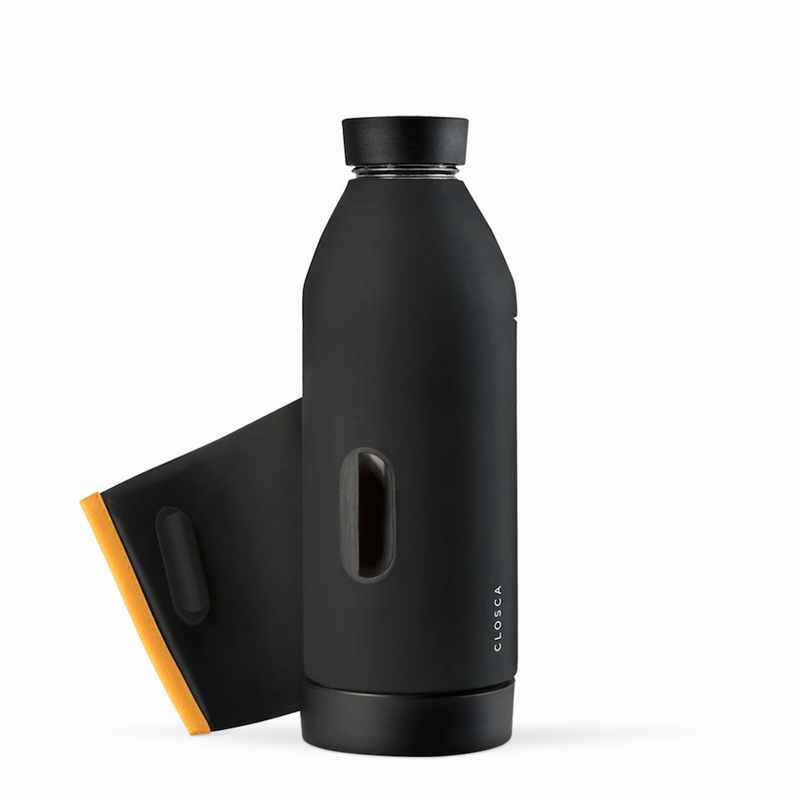 Gourde en verre avec un revêtement en silicone noir et une fixation orange. Gourde design minimaliste, pratique, deux ouverture, laniére pour fixer la gourde Closca partout, sur le vélo, le sac. Chez Robin concept store homme; boutique en ligne de cadeau pour homme. Annecy