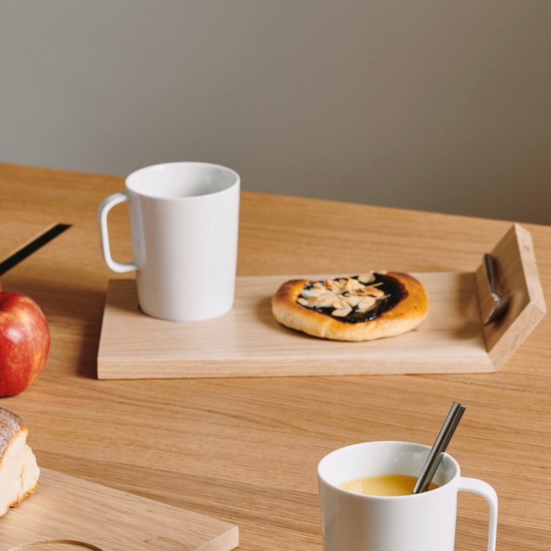 Plateau en bois avec tasse en porcellaine et cuillère aimanté sur la planche.