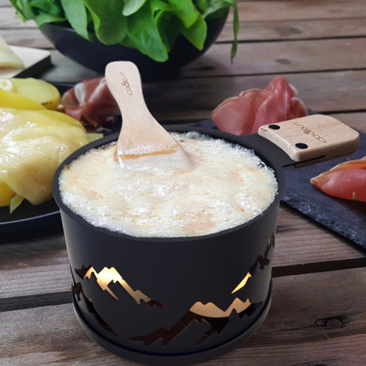 Raclette à la bougie avec fromage fondue. Montagne en décoration sur la raclette. Lumi édition limité Cookut sur Robin concept store Annecy.